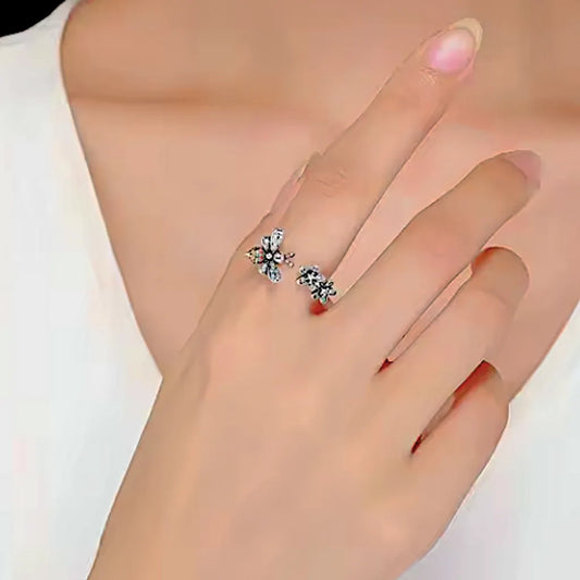 Bague abeille et fleurs belles de nuit en argent 925 portée sur une main féminine, dévoilant son design raffiné et ses zircones scintillantes.