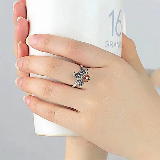 Bague abeille en argent 925 portée à la main, captée en train de tenir une tasse blanche, mettant en valeur l’éclat du cristal miel et le design raffiné.