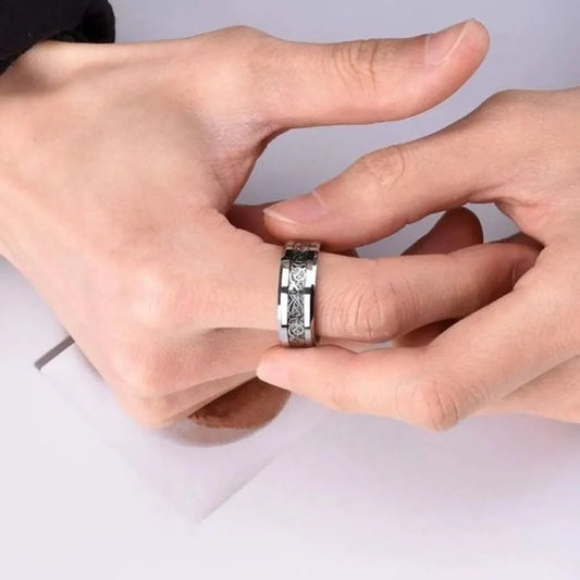 Gros plan sur la bague Dragon Celte argentée en acier inoxydable, incrustation nette sur main masculine.