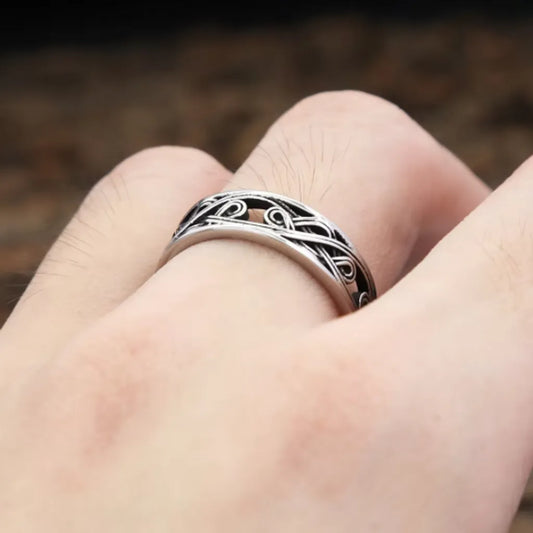 Bague homme en acier inoxydable avec motif nœud celtique, portée sur une main. Design viking argenté pour un style authentique et robuste.