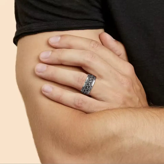 Bague Skadi portée sur main nue, mise en valeur sur avant-bras croisé, motif torsadé visible, style sobre et masculin.