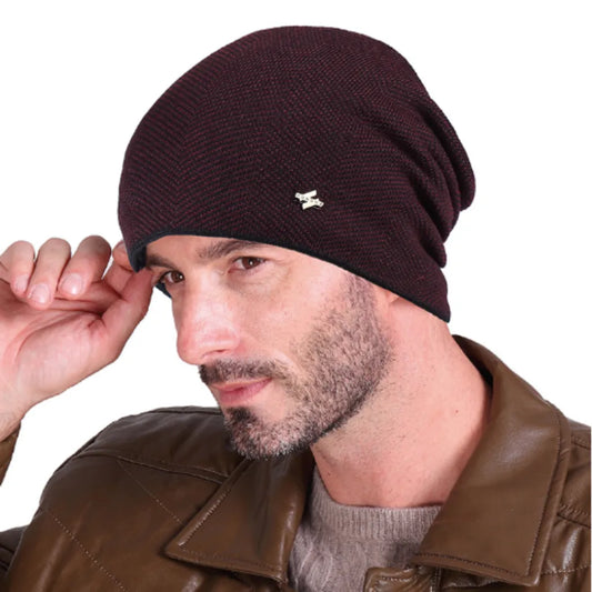 Bonnet tricoté en laine acrylique et coton de couleur bordeaux avec doublure chaude en peluche sur la tête d'un bel homme avec une barbe de deux jours.
