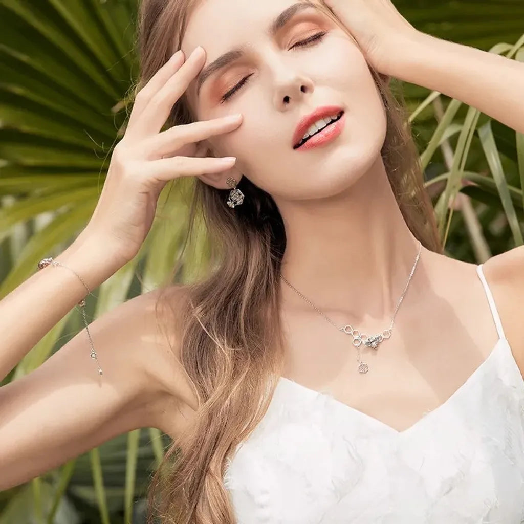 Modèle portant le bracelet Abeille Reine en parure avec boucles et collier, esprit nature, chic et estival.