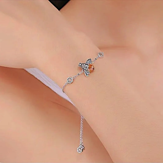 Le bracelet Abeille Reine porté au poignet, éclat subtil de l’argent 925 et cristal miel, bijou féminin délicat.