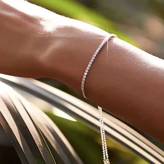 Bracelet Almeria en argent 925 porté sur un poignet bronzé sous la lumière naturelle, subtil jeu d’ombres végétales pour un style estival épuré.