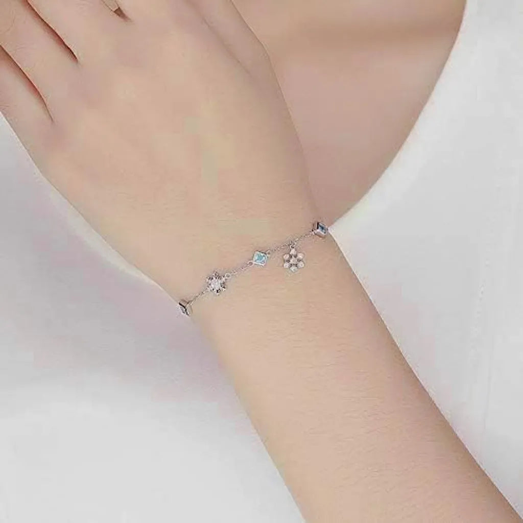 Bracelet Aeria flocon argenté porté sur bras nu, look simple et féminin pour le quotidien.