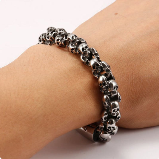 Bracelet biker crânes à têtes de mort avec fermoir crochet en acier inoxydable 316L présenté sur un poignet d'homme