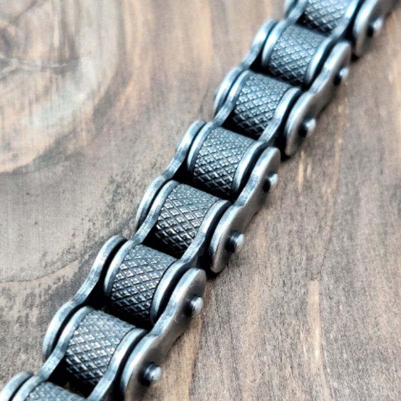 Vue zoom prise de haut du bracelet biker avec maillons de forme roulement moletés en acier inoxydable - coloris argent vieilli