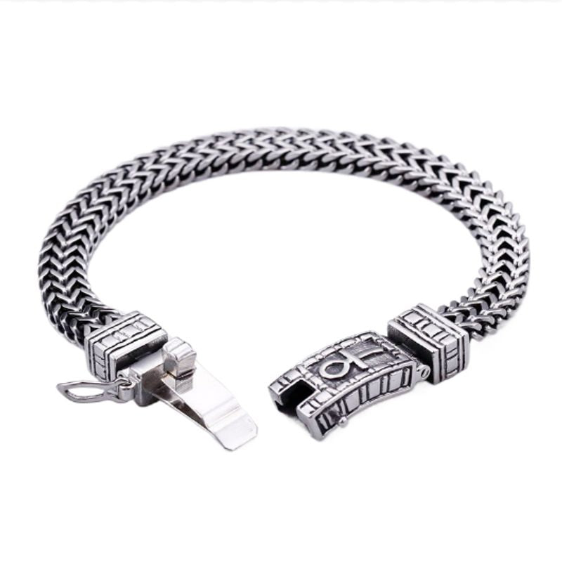 Bracelet au fermoir clip ouvert avec croix égyptienne Ankh en acier inoxydable vue de face sur un support plat à fond blanc - coloris argent
