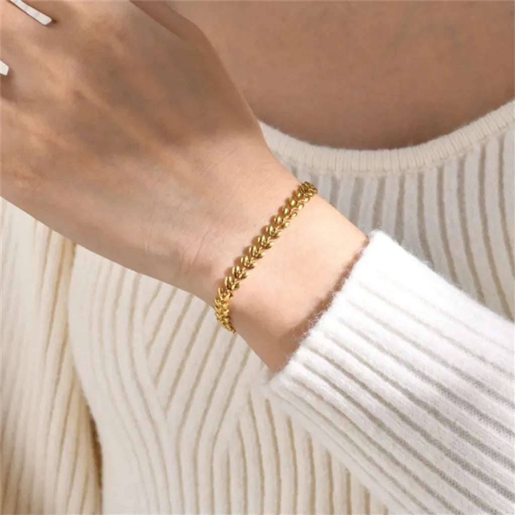Bracelet Épi de Blé porté avec élégance – style épuré, chic discret et jeu de texture entre maille dorée et maille blanche.