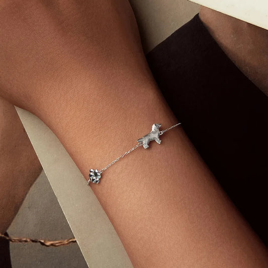 Bracelet Golden Retriever en argent 925 porté en gros plan, détail des charms sur peau nue, rendu délicat et complice.