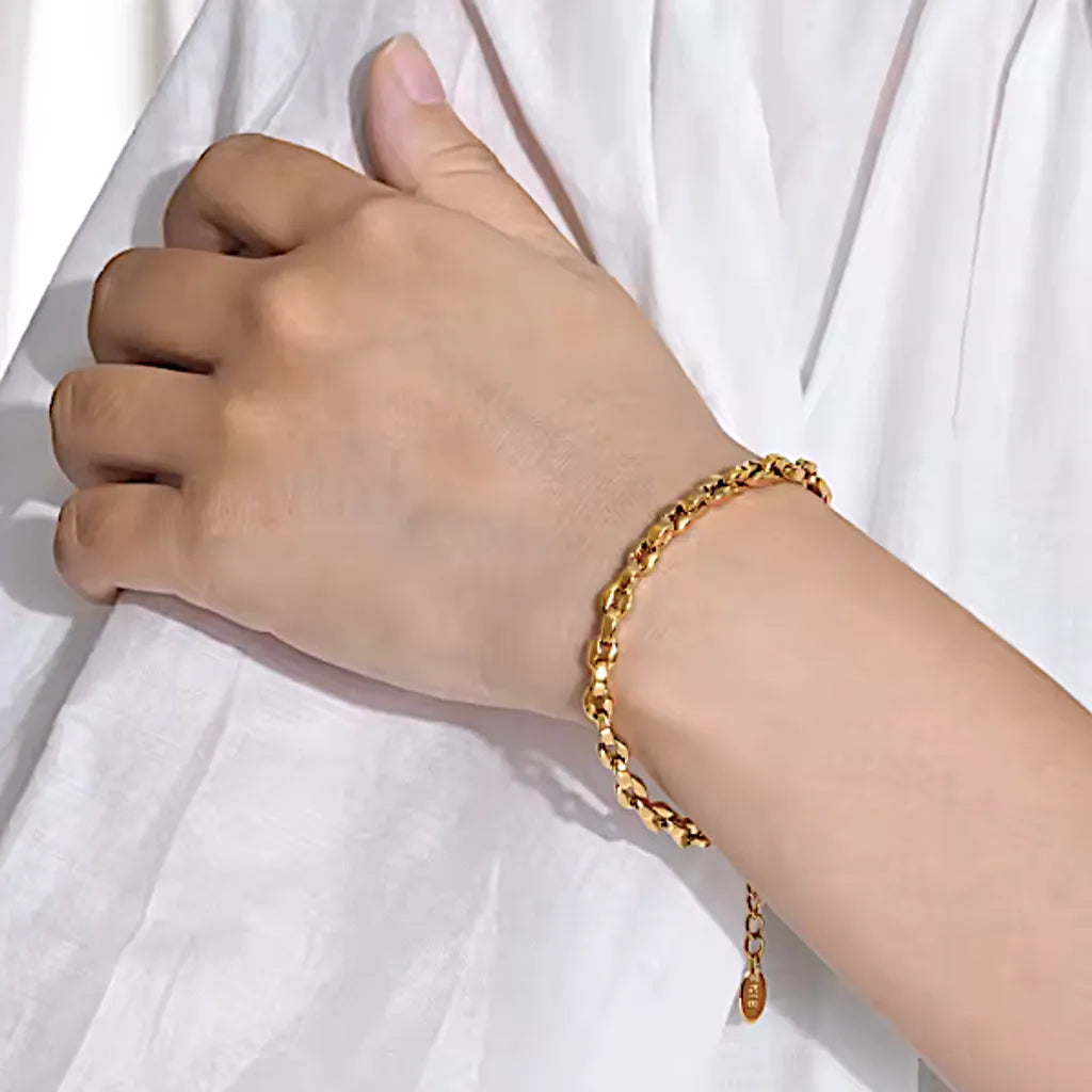 Bracelet Lunaria doré porté avec une chemise blanche, contraste subtil et allure épurée, maille brillante.