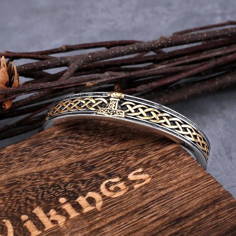 Bracelet manchette viking Hammer avec nœuds celtique en acier inoxydable reposant sur l'angle de sa boite-cadeau en bois fermé signé viking - jonc ouvert - coloris argent et or