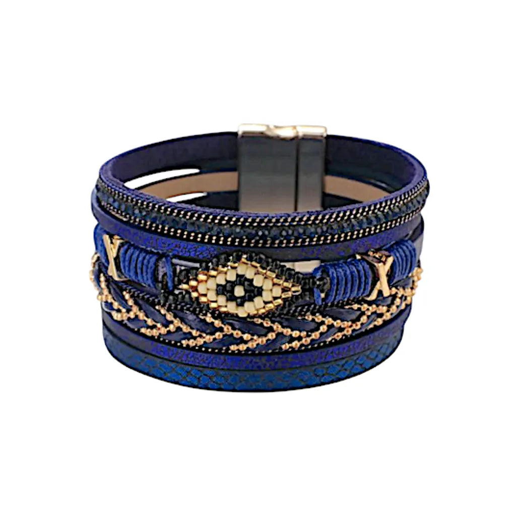 Bracelet Œil du Chaman en cuir microfibre bleu, design multi-rangs avec perles, strass et chaîne décorative, motif œil inspiré de l’art amérindien.