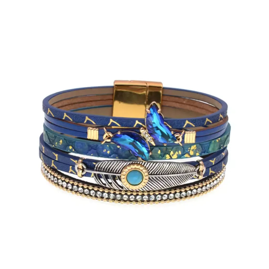 Bracelet bleu marine avec plume Quetzal et breloques papillon, pour une touche de mystère.