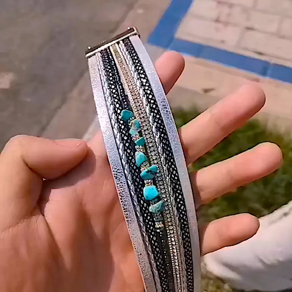 Gros plan du bracelet Pierre Horizon ouvert sur la paume d'une main de femme, montrant largeur et détails turquoise.