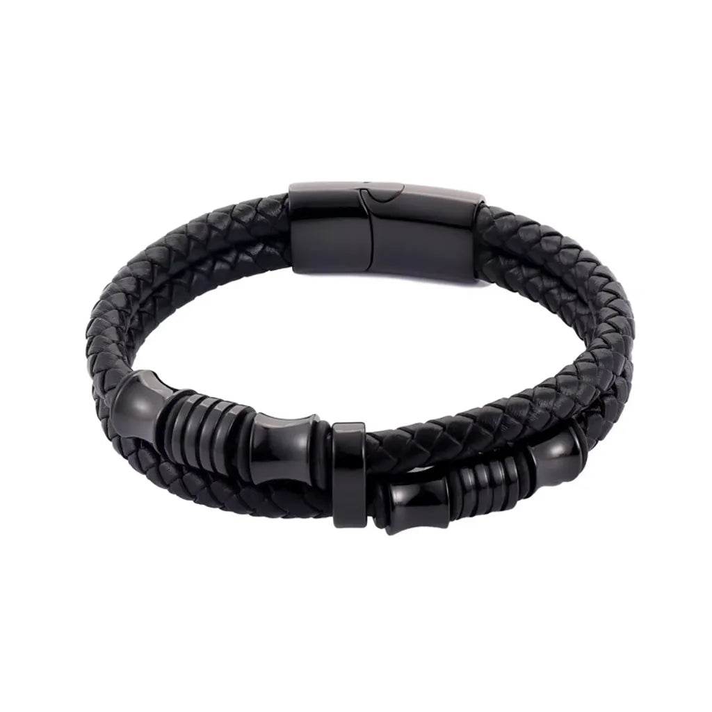 Gros plan. L'équilibre du bracelet Thao Cuir Noir Tressé est mis en valeur, contrasté par la densité du fermoir magnétique noir poli.