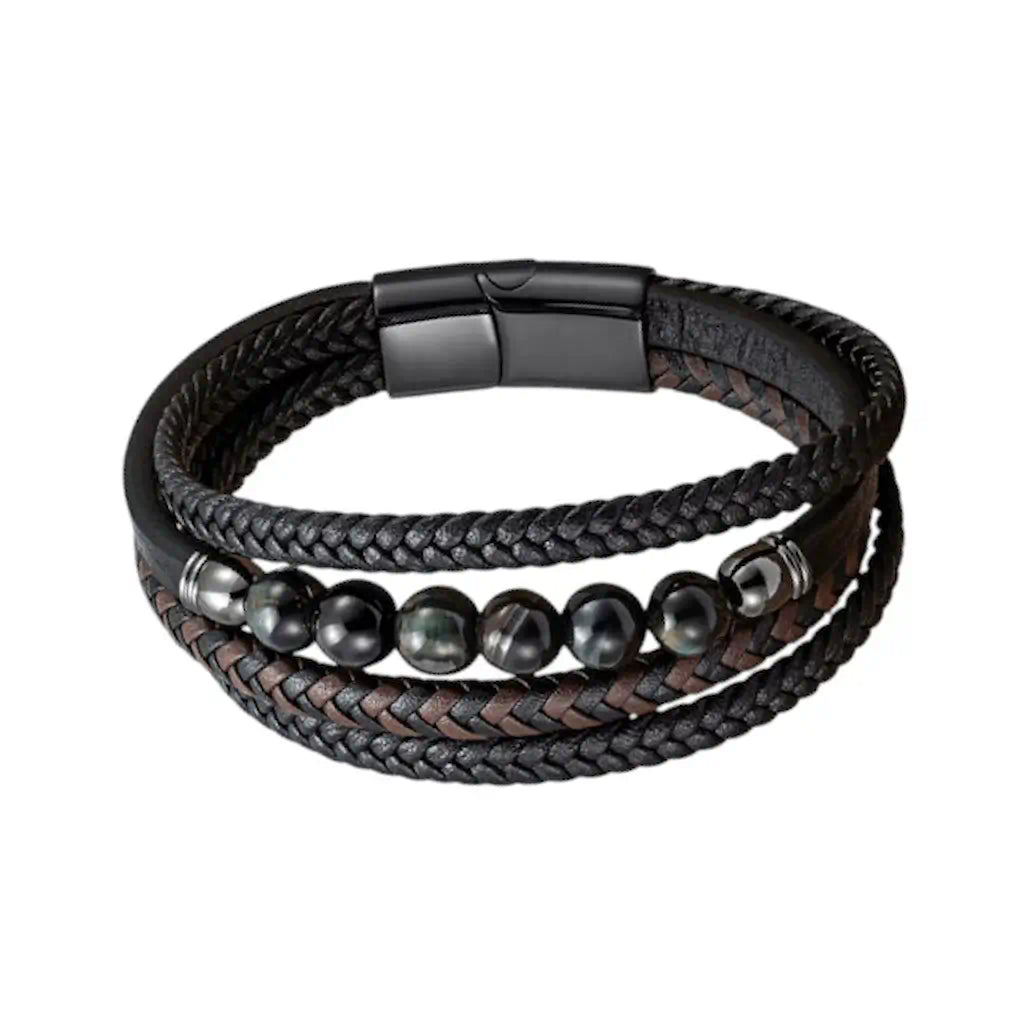 Focus sur les nuances froides des perles oeil de tigre bleu scandinave intégrées au tressage complexe du bracelet Vorg. L'alliance du cuir texturé et des reflets azurés crée une esthétique technique et souveraine.