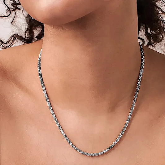 Collier Cordelia argenté porté au cou, sur peau nue, mettant en valeur l’éclat naturel de la maille torsadée.