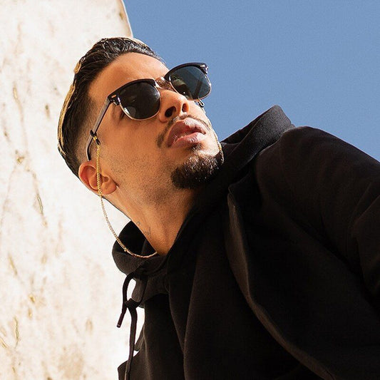 Lunettes de soleil master rondes classique avec demi-monture plastique et alliage métal doré sur le nez d'un jeune homme au look casual vêtu d'un sweat a capuche noir - coloris noir