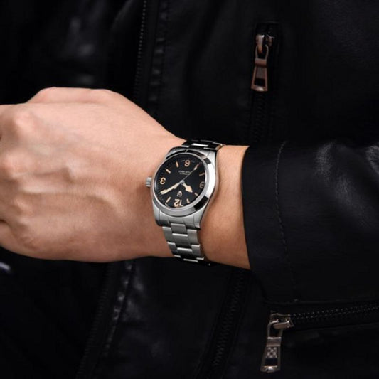 Montre hommage à la mythique Ranger - bracelet et boitier en acier inoxydable sur poignet d'un homme au blouson en cuir noir - Pagani Design