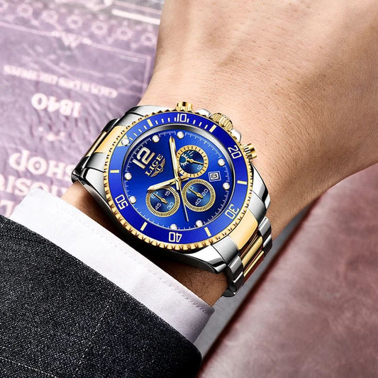 Montre de sport chronographe au poignet d'un homme en costume, ses trois sous-cadrans sont fonctionnels et son bracelet est en acier inoxydable bicolore, or et argent - cadran coloris bleu