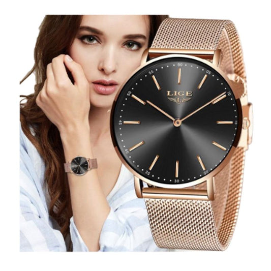Montre top mode à quartz, cadran noir et bracelet maille milanaise de couleur or rose sur un poignet d'une jeune jolie femme