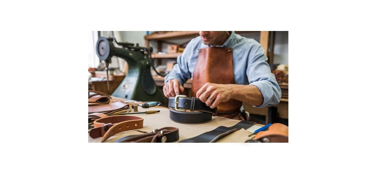 Atelier de fabrique artisanal de produit en cuir, on peut voir sur cette photo, un homme qui confectionne une ceinture en peau de vache pleine fleur.