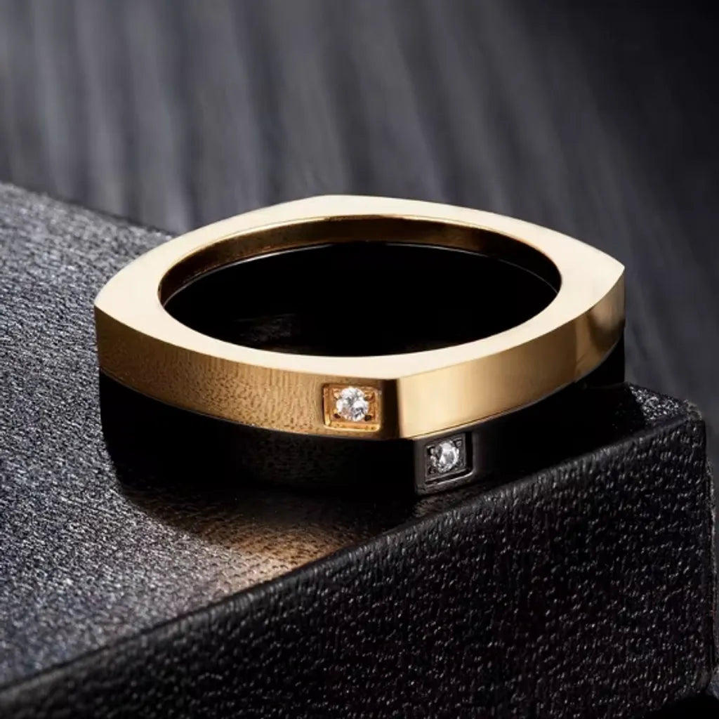 Bague carrée rotative avec zircones cubiques - Anneau pour homme en acier inoxydable présentée à plat sur un angle de boite en cuir noir – coloris or et noir.