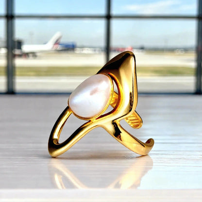 Bague Dorée Nacre Voyage Ambiance Aéroport Posée Comptoir Blanc Vitrifié Fond Flouté Avion Mira Akrochic