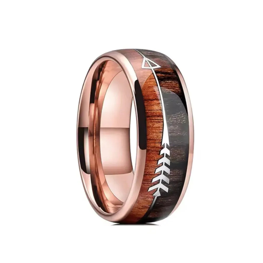 Bague Flèche Rollo en acier inoxydable doré rose avec flèche argentée, incrustée sur bois exotique brun, design moderne et symbolique.