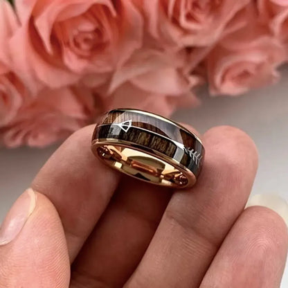 Présentation du bout des doigts de la bague Flèche Rollo dorée rose, décor romantique et rendu chaleureux, idéal pour offrir.