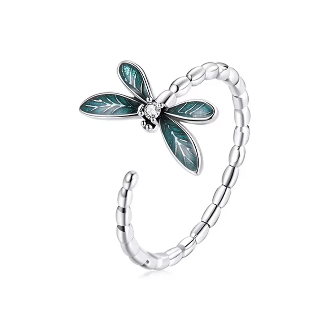 Bague libellule en argent 925 avec zircone blanche, anneau ajustable, ailes émaillées bleu-vert, fond blanc.