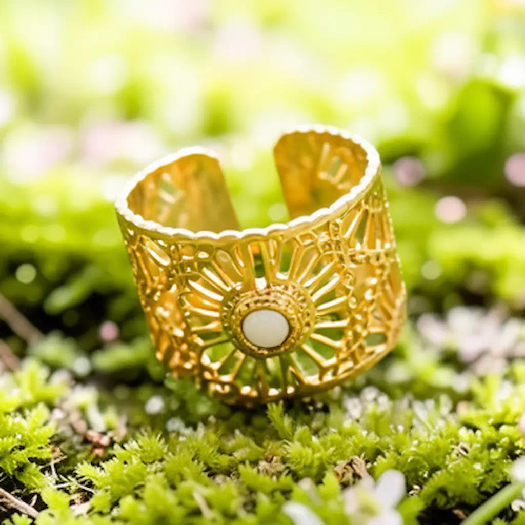 Bague Lyna face posée plat bruyère acier fusion or design soleil ajouré cabochon blanc tapis végétal naturel éclairage solaire.