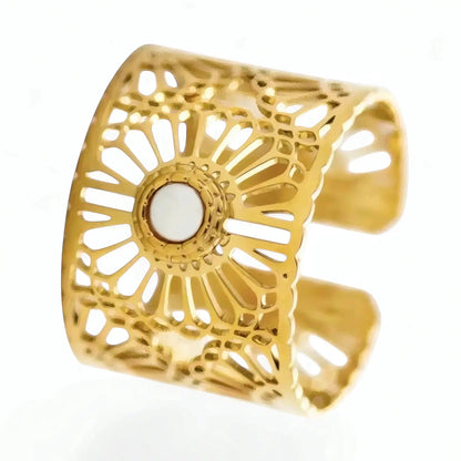 Bague Lyna ajustable acier inoxydable fusion or gros plan 3/4 face motif solaire ajouré cabochon nacre blanc structure large fond studio neutre.