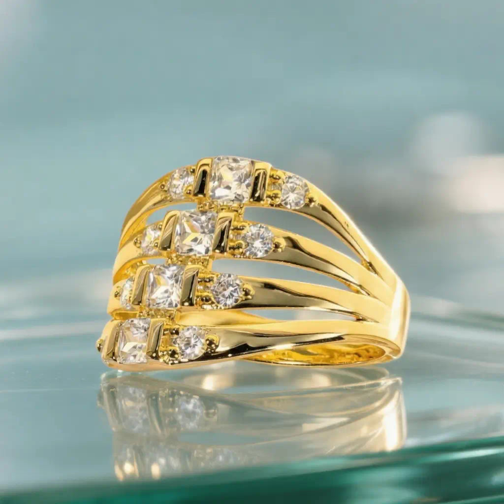 Focus de trois-quarts face sur la bague Lyra en plaqué or 14K. La transparence du support en verre magnifie le sertissage barrette des zircones et l'architecture des anneaux évasés.