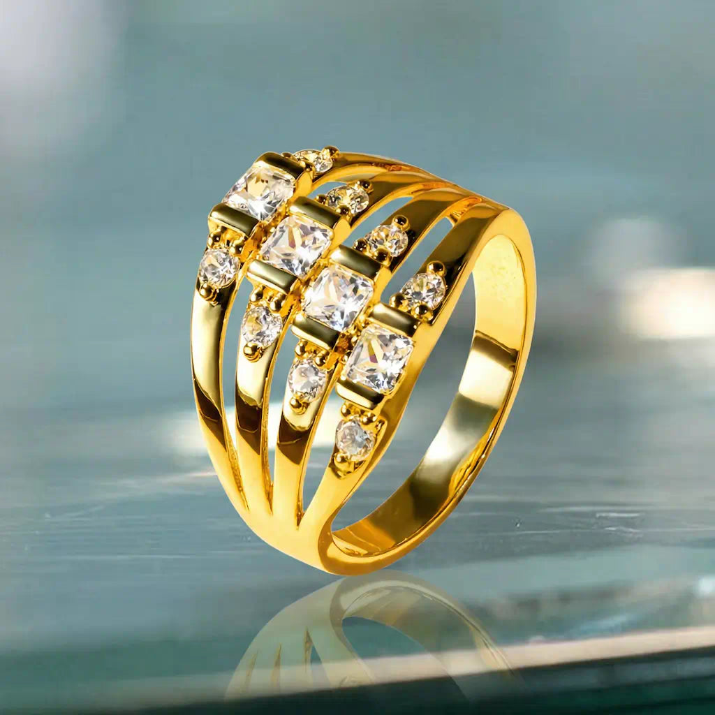 Perspective inclinée de la bague Lyra en plaqué or 14K dressée sur verre. Le décor lumineux sublime le montage des quatre lignées de zircones blanches et leur base dorée.