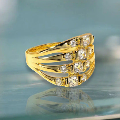 Vue de trois-quarts de la bague Lyra en plaqué or 14K posée à plat. L'exposition lumineuse souligne l'alignement des zircones et la structure évasée du motif central.