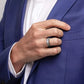 Bague rang de brique en acier inoxydable autour de l'annulaire d'une main d'homme portant un costume bleu et une chemise blanche – Acier coloris argent.