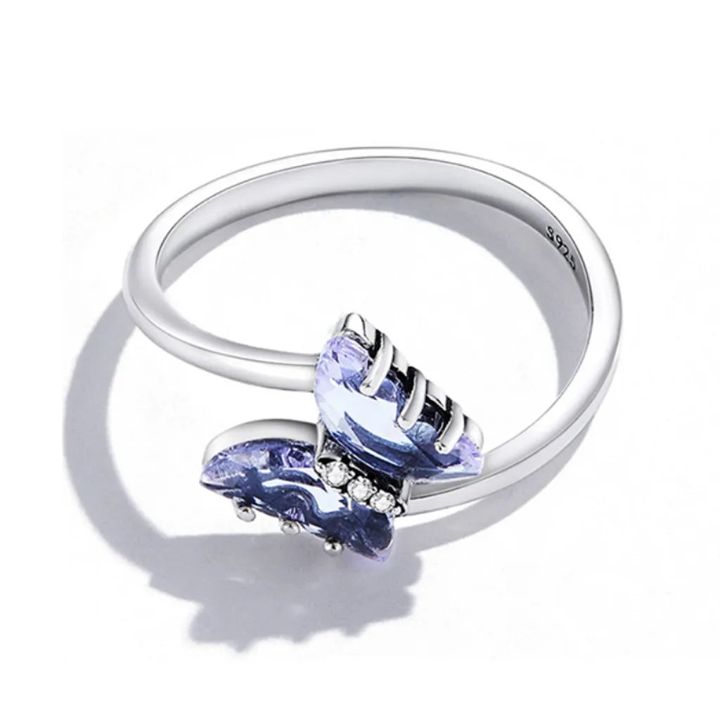 Bague papillon en argent 925 vue à plat de haut, avec son cristal violet éclatant et ses zircones lumineuses. L’ombre subtile sur fond blanc apporte un effet naturel au bijou.