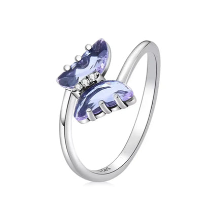 Bague en argent avec un papillon en cristal violet, vue de trois-quarts face en position droite. Les détails des zircones et la finesse du design sont mis en valeur sur fond blanc.