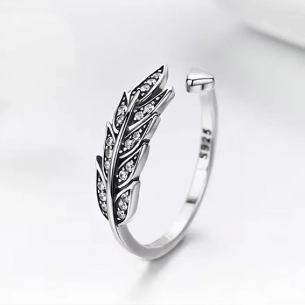 Bague plume Crécerelle en argent 925 ornée de zircones, positionnée droite avec une vue trois-quarts face. Le fond blanc avec une ombre délicate rehausse l’éclat des pierres et la finesse de la gravure de la plume.