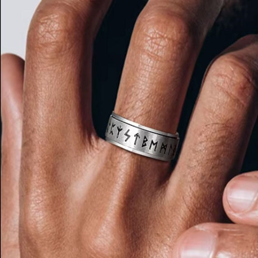 Bague Rune Viking rotative en acier inoxydable autour du doigt majeur d'une main gauche d'un homme – coloris argent.