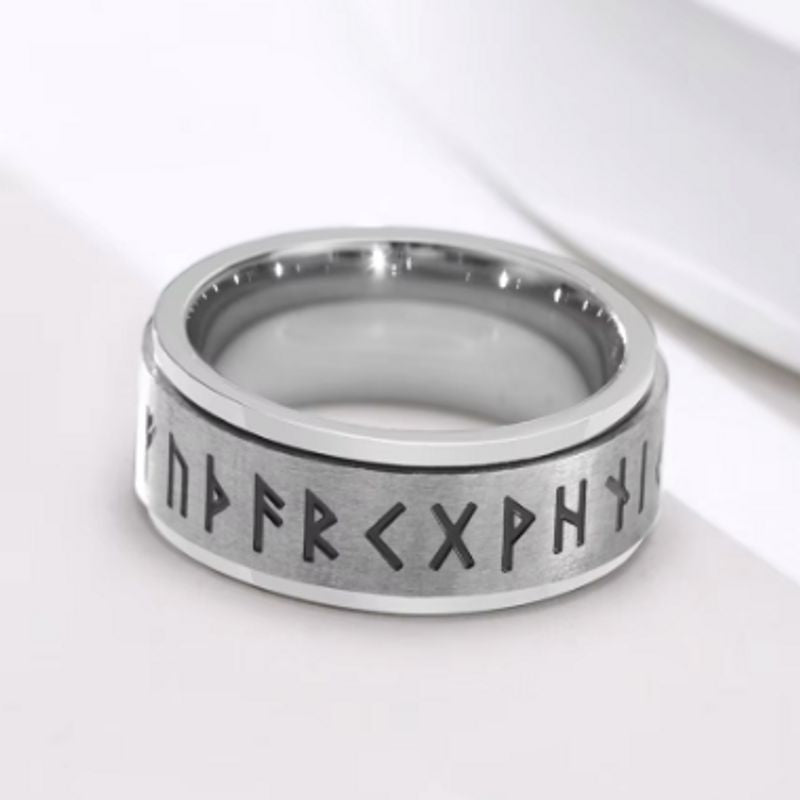 Bague Rune Viking, anneau rotatif en acier inoxydable pour homme posée à plat sur un fond blanc – coloris argent.