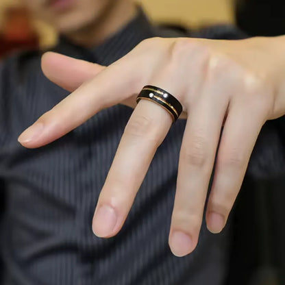 Homme élégant portant la bague Stella en acier noir avec rainure dorée, main détendue en avant.
