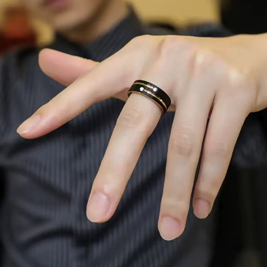 Homme élégant portant la bague Stella en acier noir avec rainure dorée, main détendue en avant.