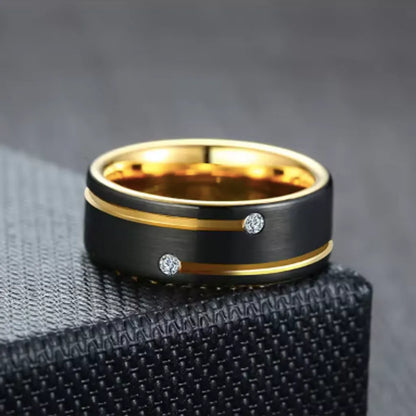 Bague Stella pour homme en acier inoxydable présentée à plat, posée sur un angle de boite en cuir noir – coloris doré et noir.