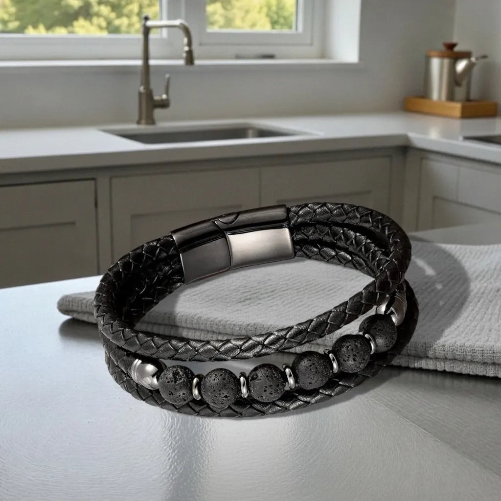 Vue de face du bracelet multi-rangs Vulcan posé à plat sur une table moderne et un torchon, soulignant l'élégance du fermoir magnétique noir sous une lumière naturelle venant de l'extérieur.