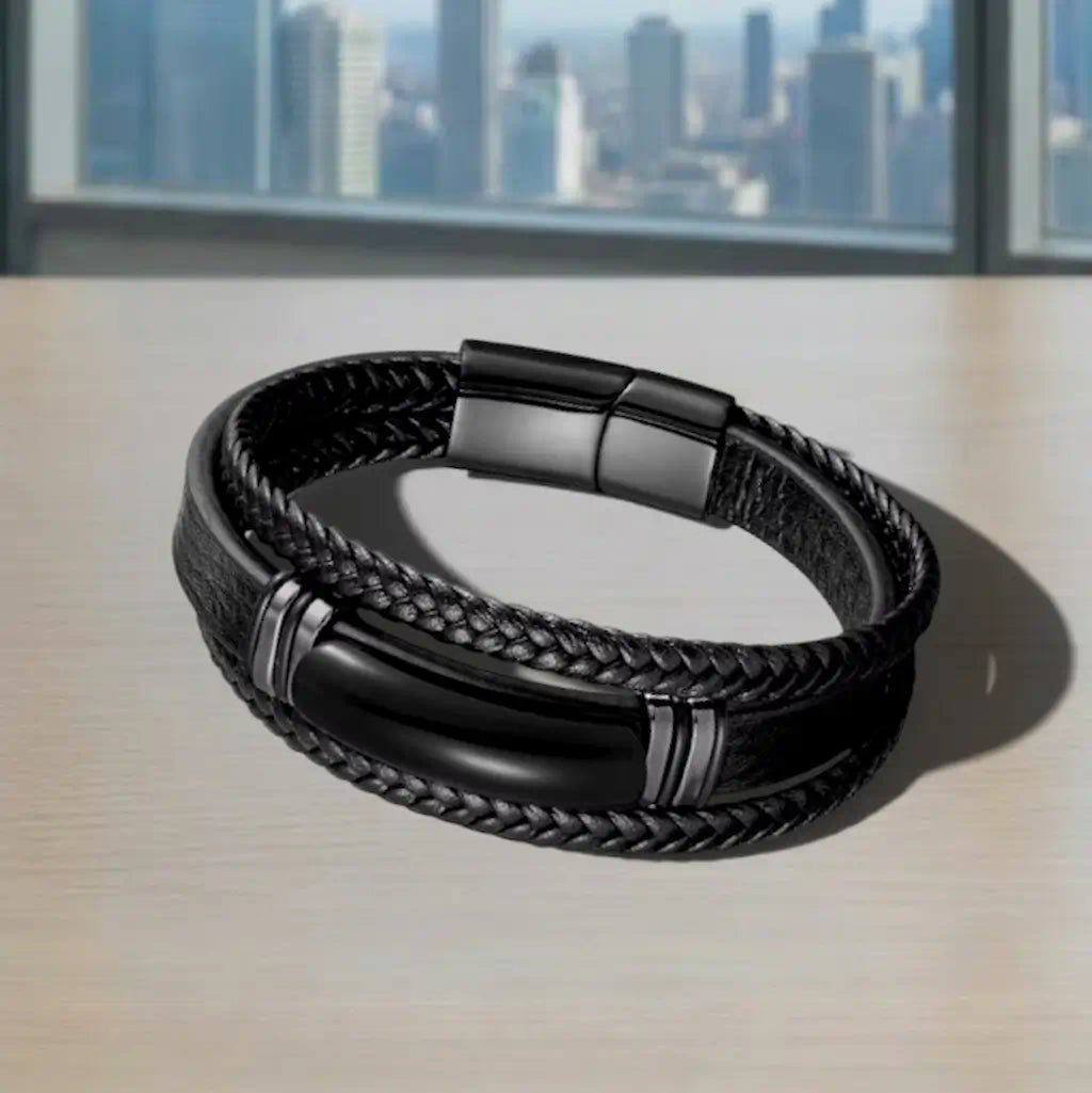 Composition horizontale du Bracelet Obsidian à plat montrant l'alliance de l'agate noire et du cuir noir sous la clarté d'une baie vitrée citadine.