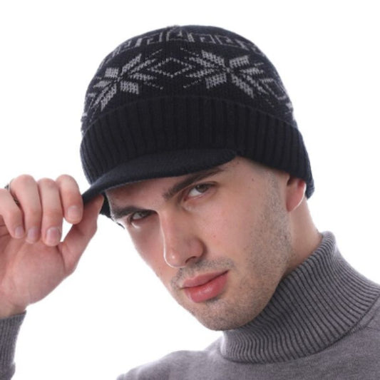 Bonnet sport Fargo à visière en laine grise sur la tête d'un homme tenant de la main droite la visière et vêtu d'un pull gris à col roulé 